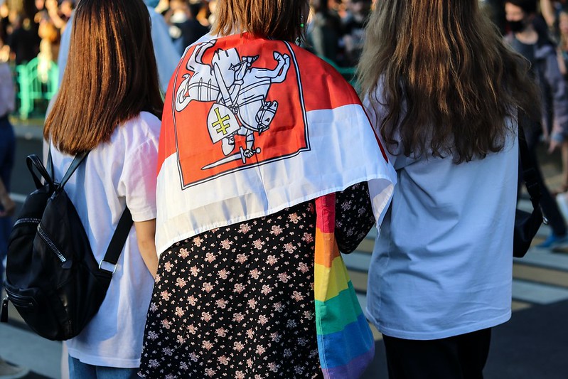 A protestor in Minsk wraps their shoulders in the flag of the BNR.